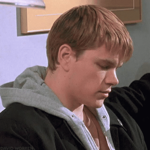 A Man With Red Hair Is Wearing A Black Jacket And A Gray Hoodie . GIF