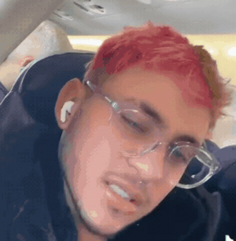 A Man With Red Hair Is Wearing Glasses And Earbuds GIF