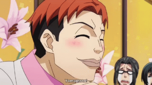 A Man With Red Hair Says Yamamoto In Front Of Some Flowers GIF