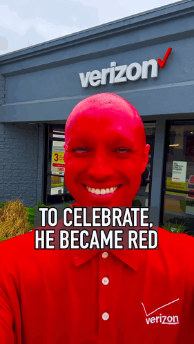 A Man With Red Paint On His Face Is Smiling In Front Of A Verizon Store GIF
