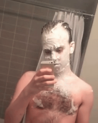 A Man With Shaving Cream On His Face Is Taking A Picture Of Himself GIF