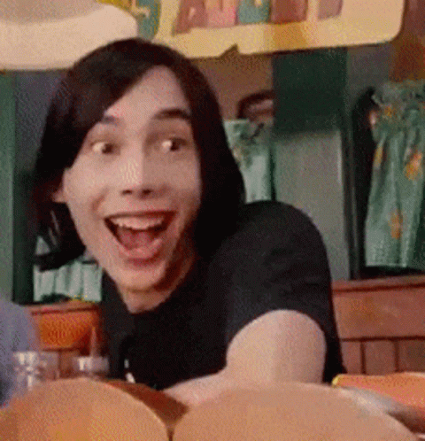 A Man With Short Hair Is Smiling With His Mouth Open GIF