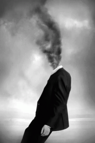 A Man With Smoke Coming Out Of His Head In A Black And White Photo GIF