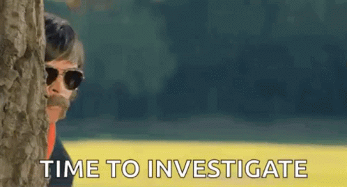 A Man With Sunglasses And A Mustache Is Peeking Out From Behind A Tree . GIF