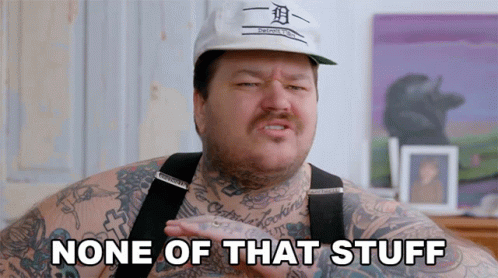 A Man With Tattoos And A Hat That Says None Of That Stuff GIF