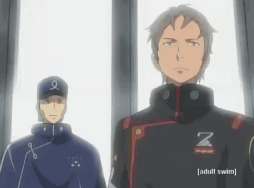 A Man With The Letter Z On His Jacket Is Standing Next To Another Man GIF
