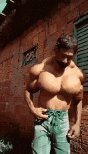 Muscular Man Standing In Front Of Brick Wall GIF