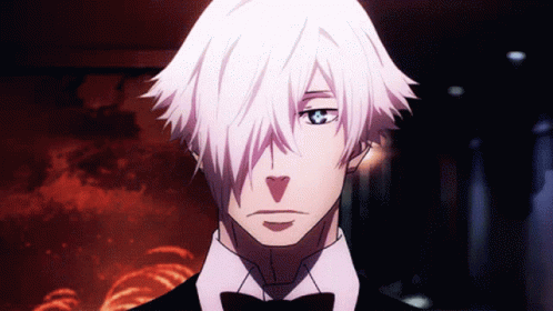 A Man With White Hair And A Bow Tie Looks At The Camera GIF