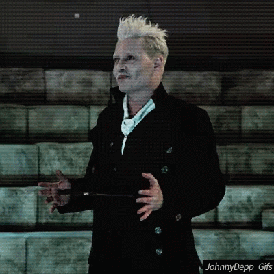 A Man With White Hair And A Mustache Is Standing In Front Of A Row Of Bleachers . GIF