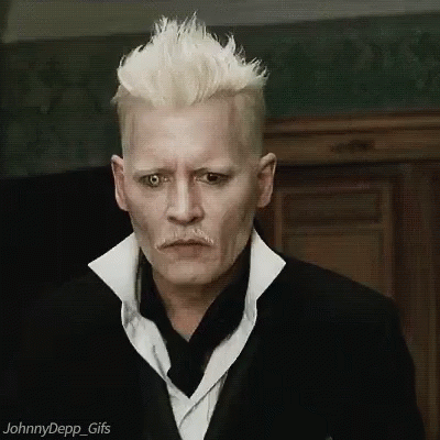 A Man With White Hair And A Mustache Is Wearing A Black Suit And White Shirt . GIF