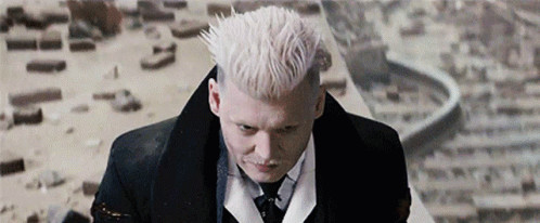 A Man With White Hair And A Mustache Is Wearing A Tuxedo And Tie . GIF
