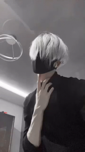 A Man With White Hair Is Wearing A Black Mask . GIF