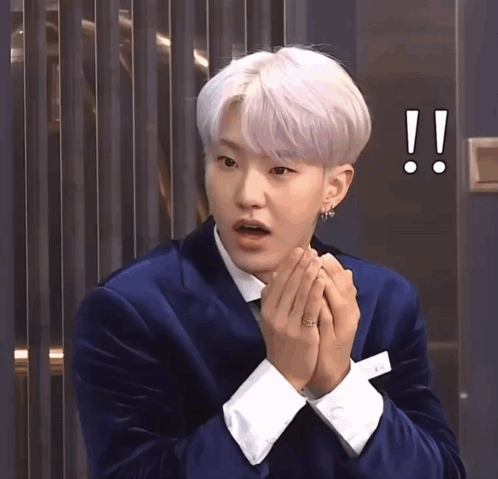 A Man With White Hair Is Wearing A Blue Suit And White Cuffs GIF