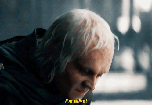 A Man With White Hair Says " I 'M Alive " In Yellow Letters GIF