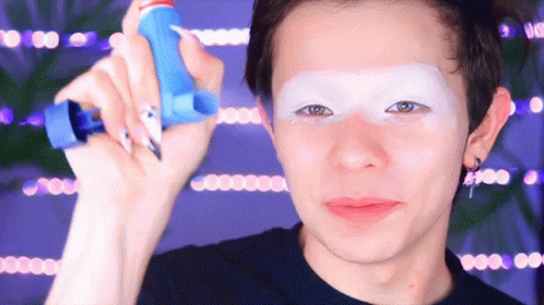 A Man With White Paint On His Face Is Holding A Blue Bottle GIF