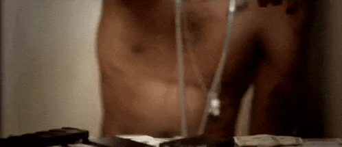 A Man Without A Shirt Is Brushing His Teeth With A Glass Of Water GIF