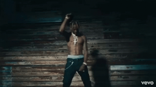 A Man Without A Shirt Is Dancing In Front Of A Wooden Wall And The Word Vevo Is On The Bottom GIF
