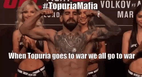 A Man Without A Shirt Is Flexing His Muscles In Front Of Three Women . GIF