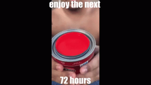 A Man Without A Shirt Is Holding A Black Container With A Red Liquid Coming Out Of It . GIF