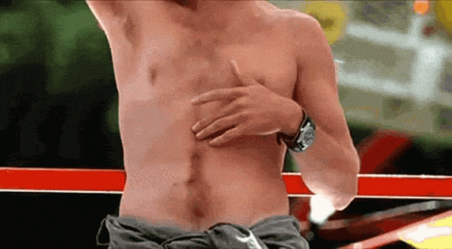 A Man Without A Shirt Is Holding His Chest With His Hand GIF