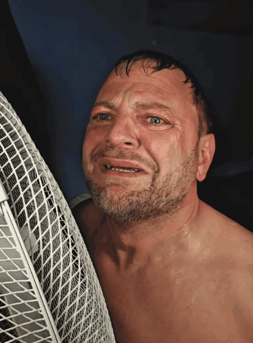 A Man Without A Shirt Is Leaning Against A Fan With His Eyes Closed GIF