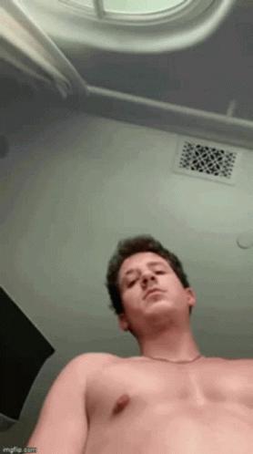 A Man Without A Shirt Is Looking Up At The Ceiling GIF