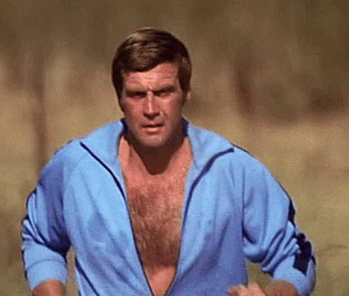 A Man Without A Shirt Is Running In A Field GIF