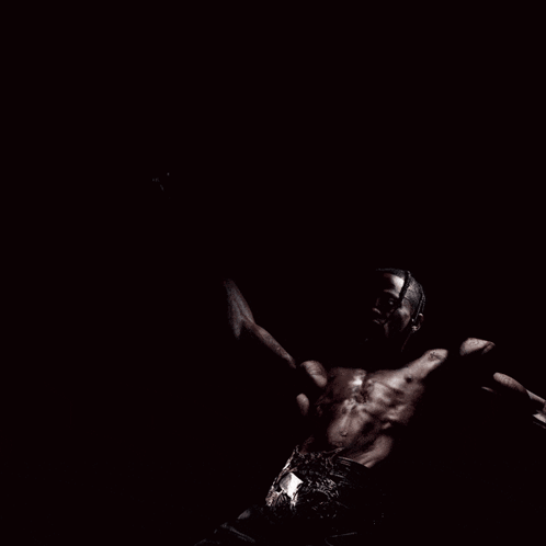 A Man Without A Shirt Is Screaming With His Arms Outstretched GIF