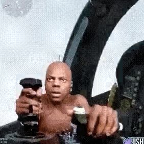 A Man Without A Shirt Is Sitting In The Cockpit Of A Plane Holding A Remote Control . GIF