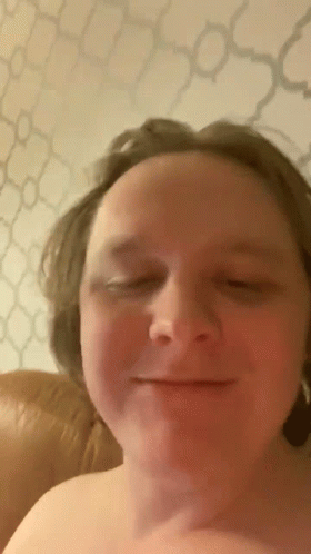 A Man Without A Shirt Is Smiling With His Eyes Closed . GIF