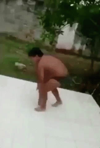 A Man Without A Shirt Is Squatting Down On A White Surface . GIF