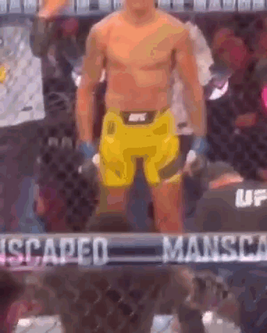 A Man Without A Shirt Is Standing In A Boxing Ring . GIF