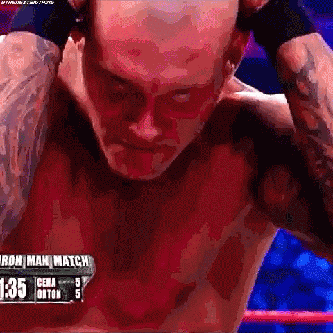 A Man Without A Shirt Is Standing In A Boxing Ring With His Hands Behind His Head . GIF