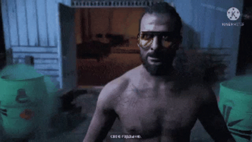 A Man Without A Shirt Is Standing In A Dark Room With A Green Barrel In The Background And A Watermark For Kinemaster GIF
