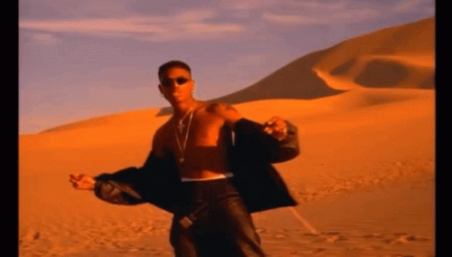 A Man Without A Shirt Is Standing In A Desert GIF