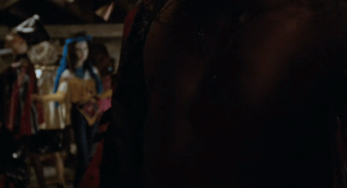 a man without a shirt is standing in a room