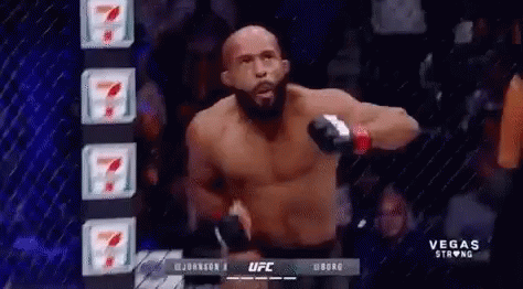 A Man Without A Shirt Is Standing In Front Of A Cage In A Ufc Fight . GIF