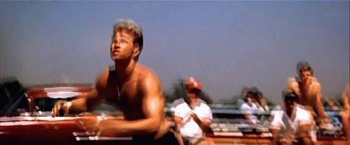 A Man Without A Shirt Is Standing In Front Of A Car GIF