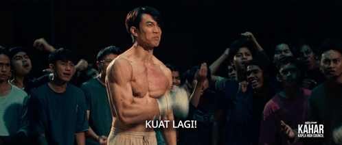 A Man Without A Shirt Is Standing In Front Of A Crowd And The Caption Kuat Lagi GIF