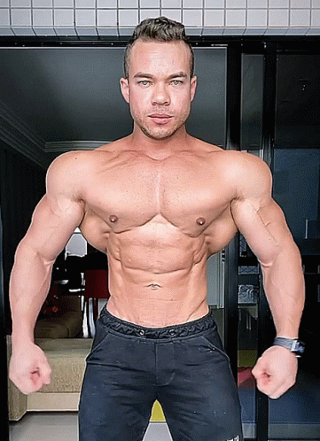 A Man Without A Shirt Is Standing In Front Of A Door With His Hands On His Hips GIF