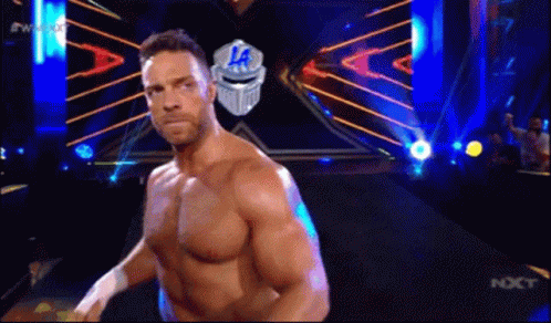 A Man Without A Shirt Is Standing In Front Of A Sign That Says ' La ' On It . GIF
