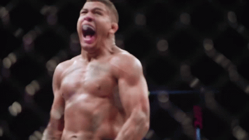 A Man Without A Shirt Is Standing In Front Of A Ufc Logo GIF
