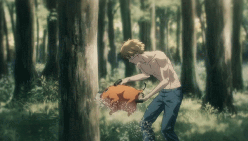 A Man Without A Shirt Is Standing In The Woods Holding A Pig GIF