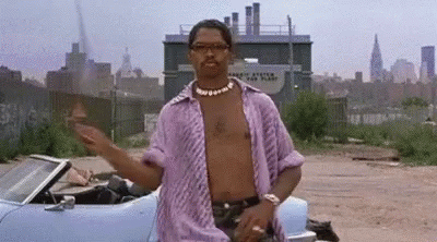 A Man Without A Shirt Is Standing Next To A Blue Car . GIF