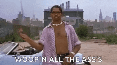 A Man Without A Shirt Is Standing Next To A Convertible Car In A Dirt Field . GIF