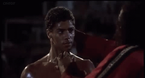 a man without a shirt is standing next to another man in a boxing ring .