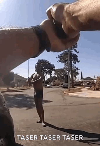 A Man Without A Shirt Is Standing On The Side Of The Road Being Held By Another Man 'S Hand . GIF