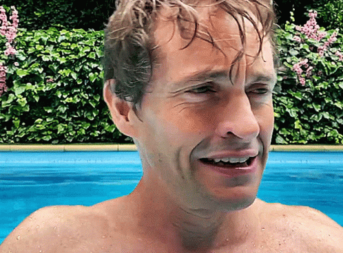 A Man Without A Shirt Is Swimming In A Pool With His Mouth Open GIF