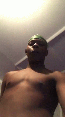 A Man Without A Shirt Is Taking A Selfie In A Dark Room GIF
