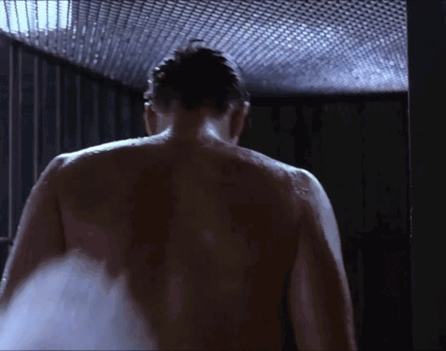 A Man Without A Shirt Is Taking A Shower GIF